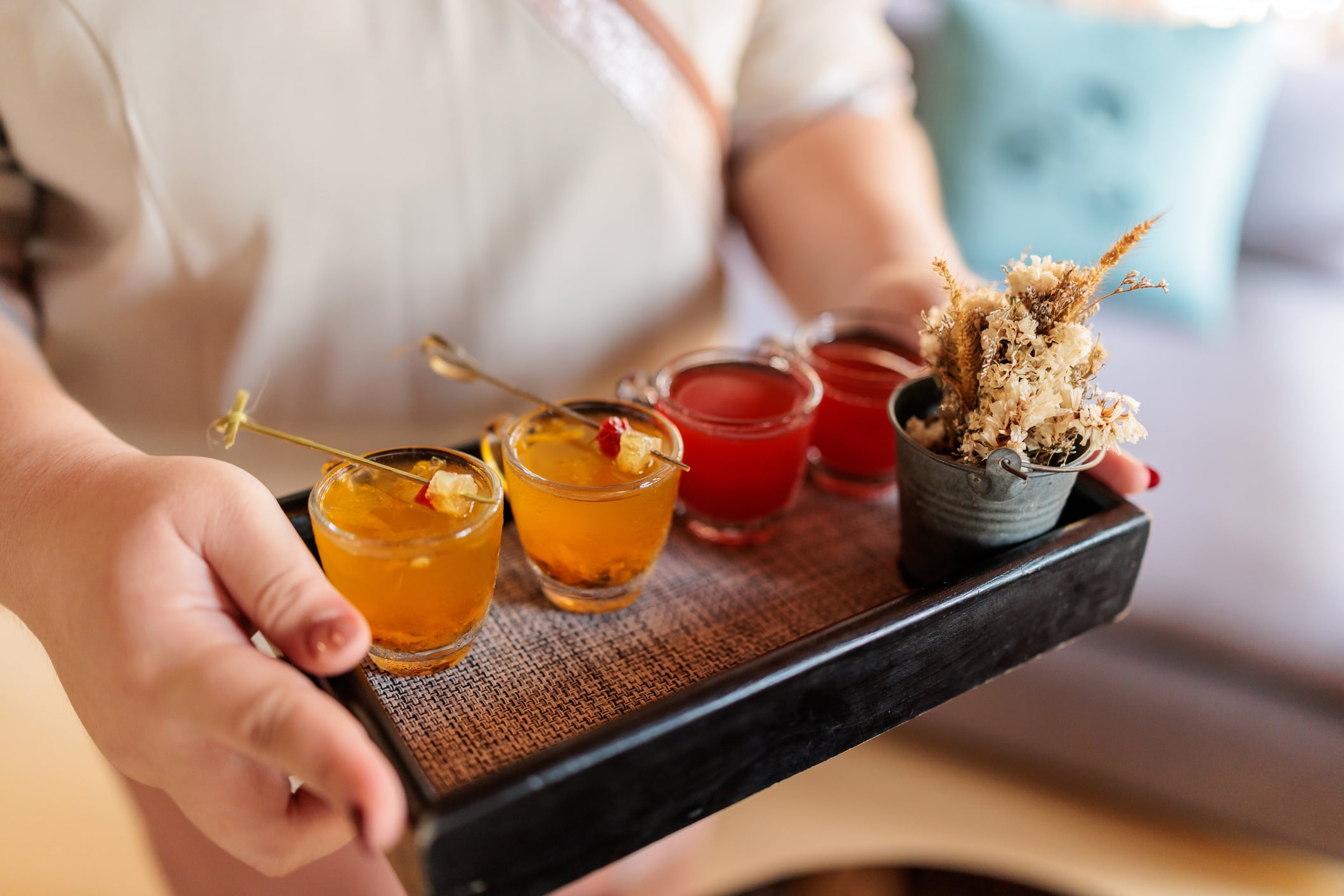 Tray with four small, beautifully decorated glasses of summer refreshing welcome juice.