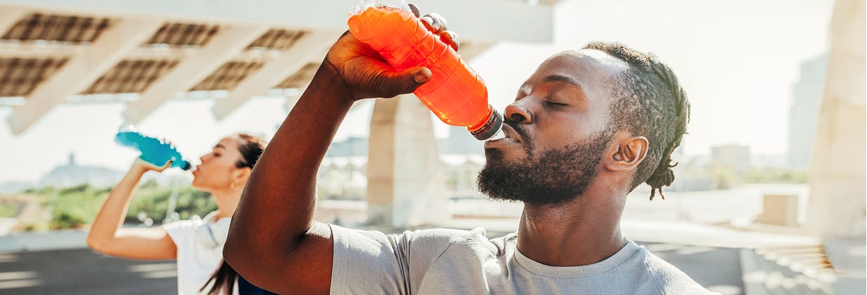 man drinking colourful beverage