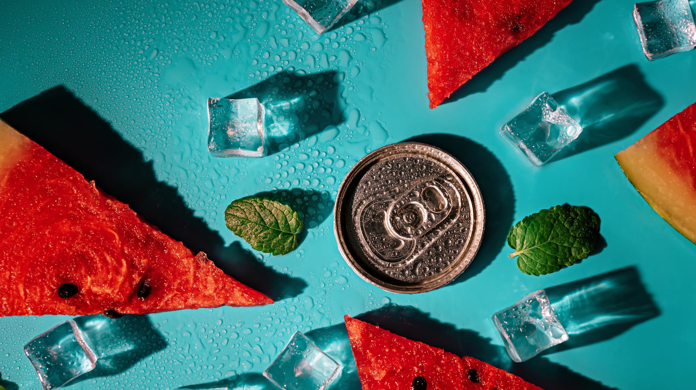 Creative summer composition with watermelon, mint leaves, can of soda and ice cubes. Top down minimal watermelon drink concept.