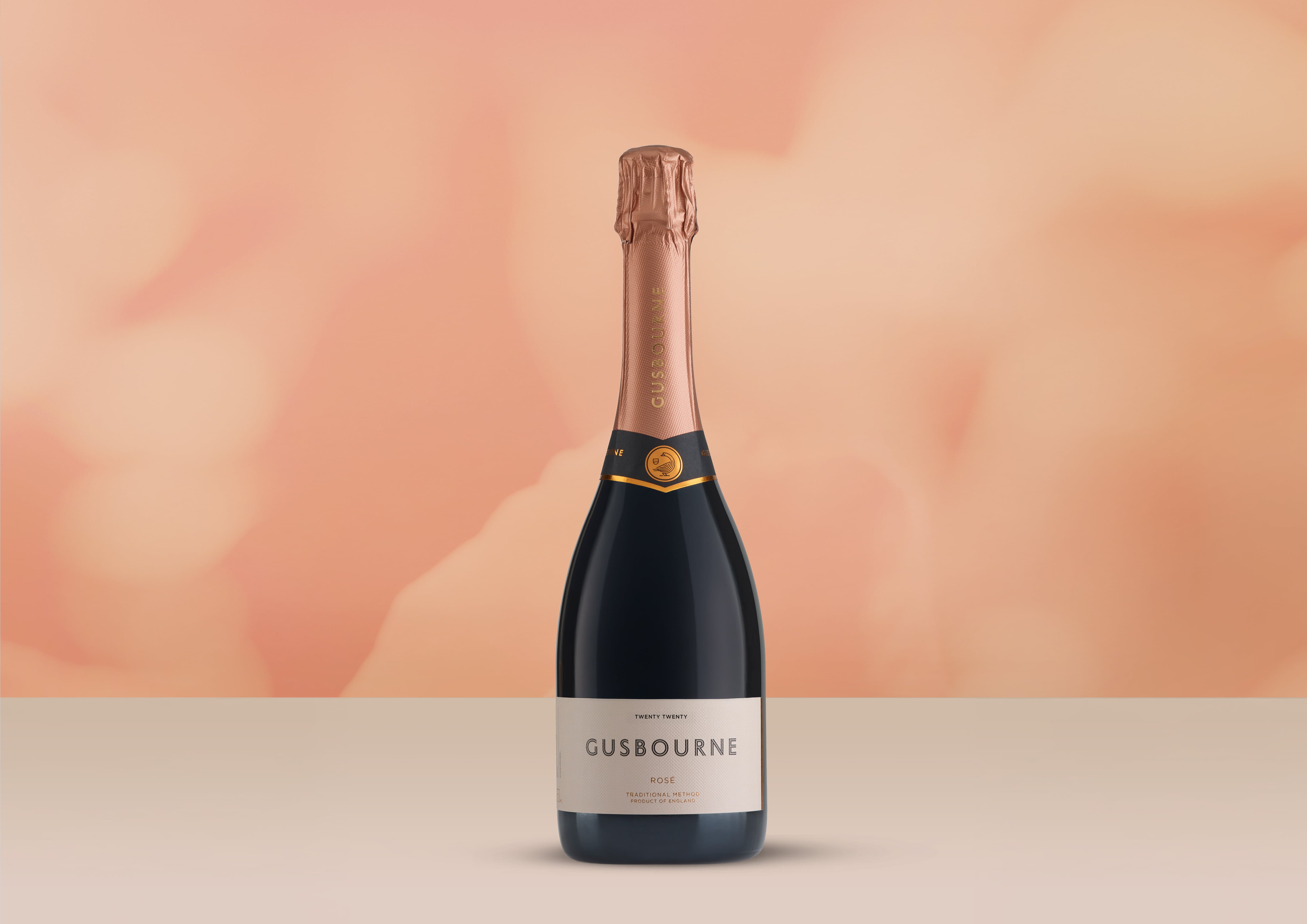 Bottle of Gusbourne Rosé 2020 with vineyard backdrop.