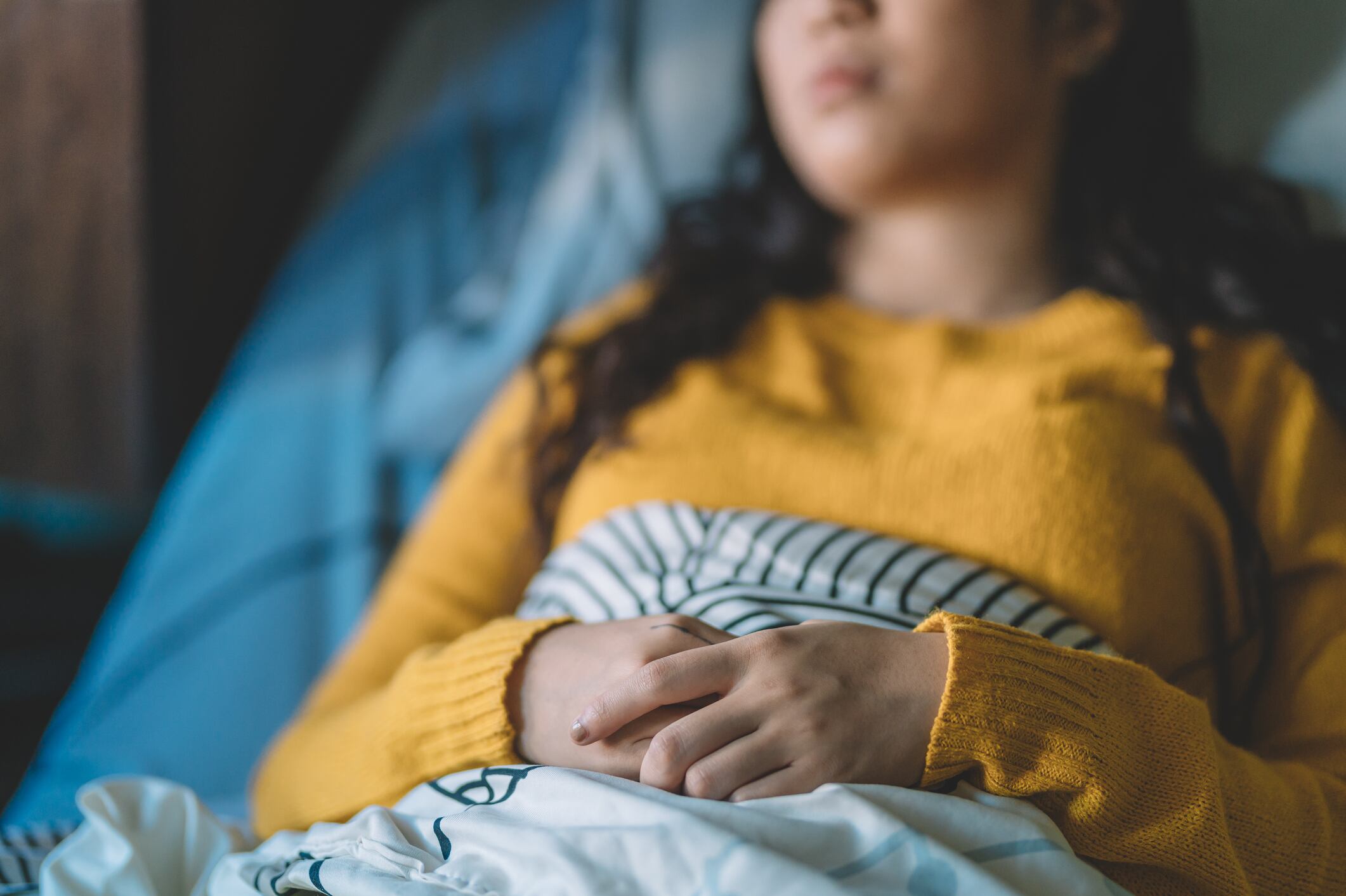 an asian chinese female teenage sick and lying on bed in the hospital ward