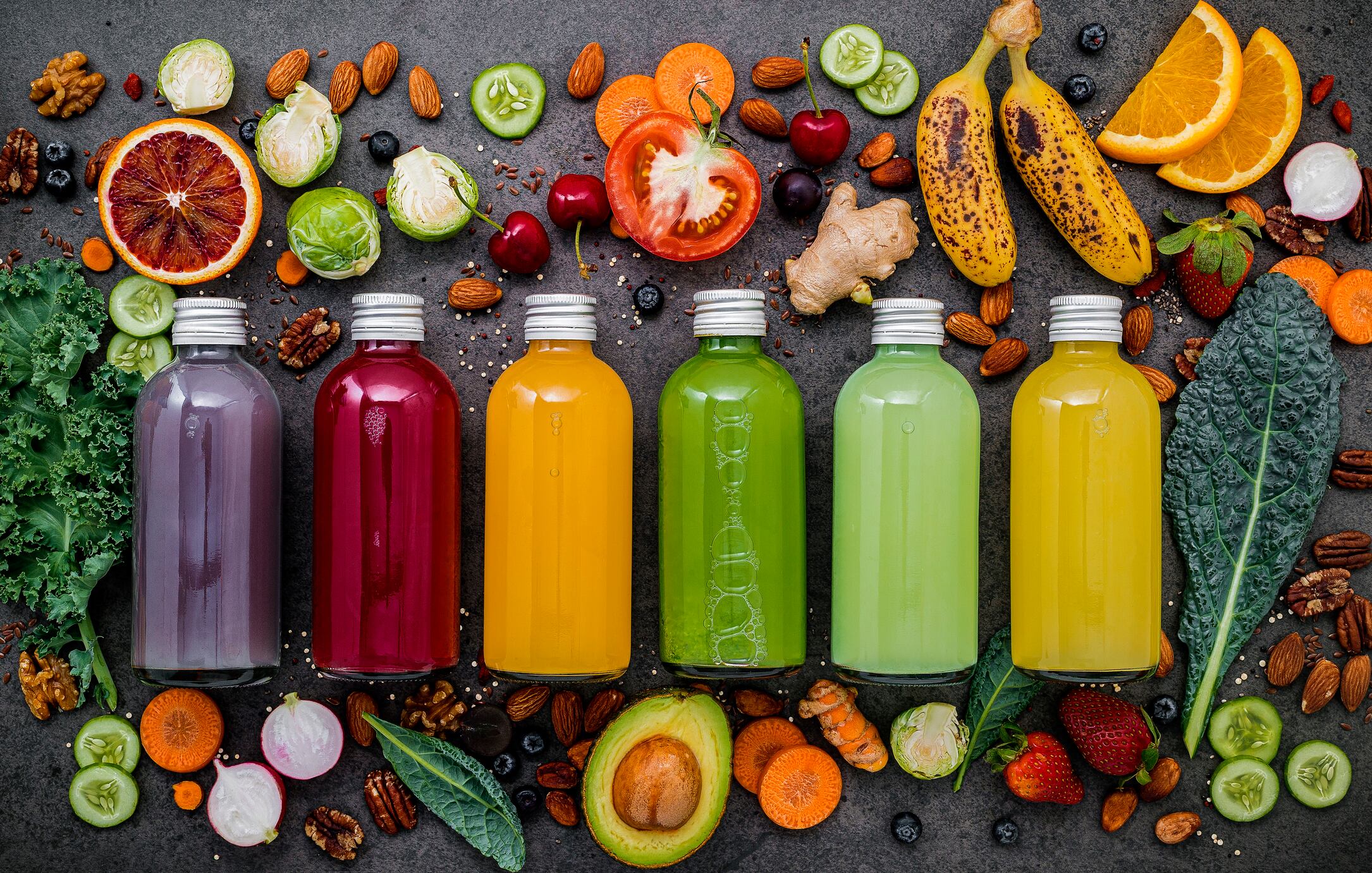 Colourful drinks in bottles with fresh tropical fruit and superfoods