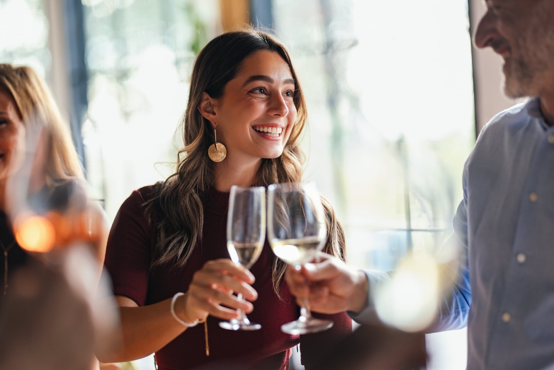 A group of friends gathers around, raising flutes in a festive toast. Bright smiles and warm light capture a lively, elegant celebration of friendship, laughter, and shared moments.