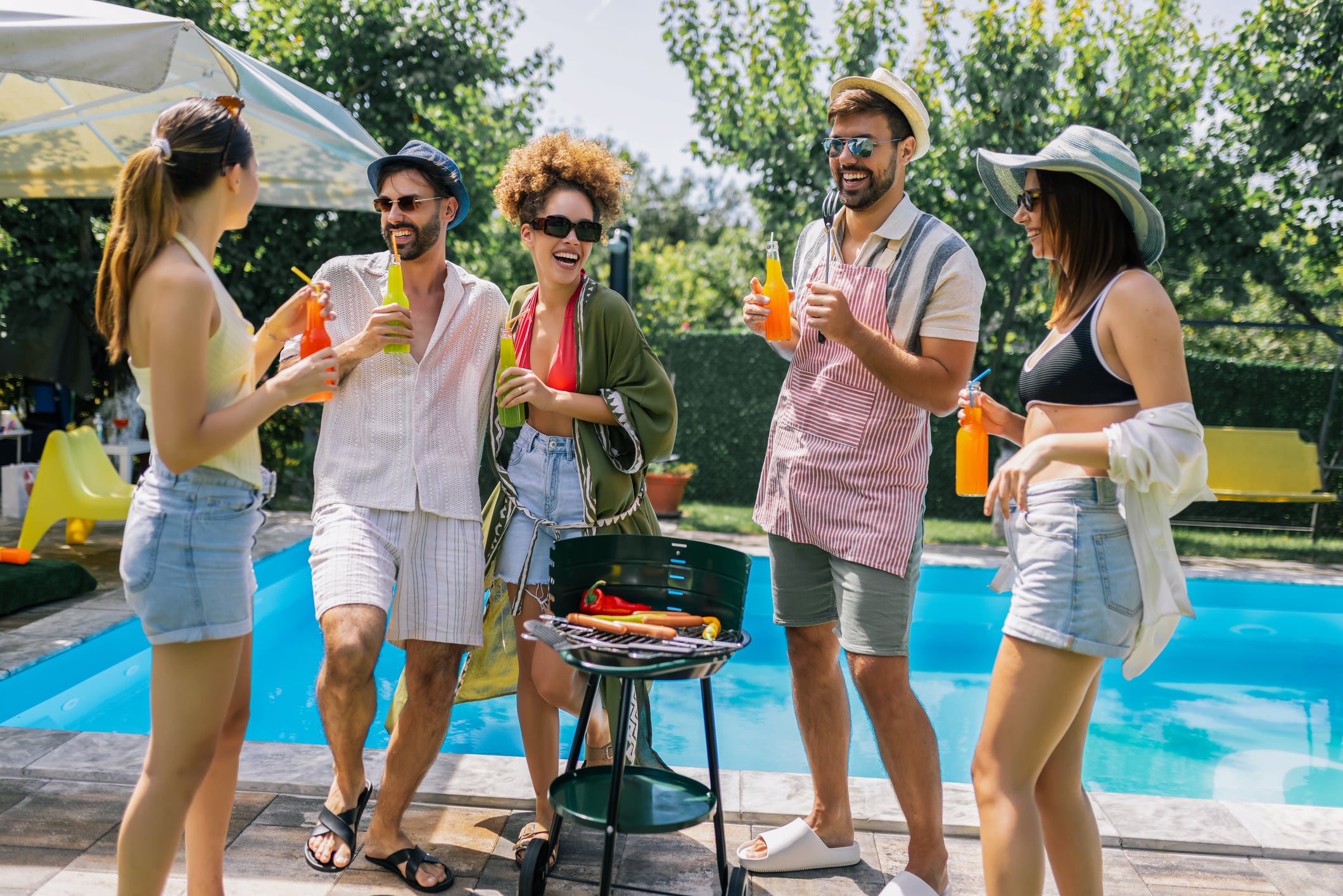 Young people drinking by a pool