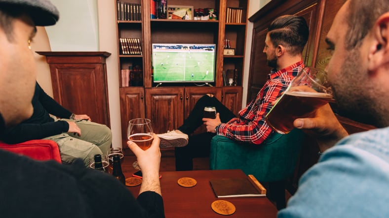 Man having a beer and watching soccer at the pub