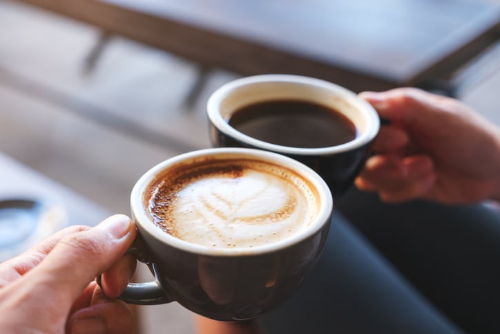 Coffee mugs being clinked together
