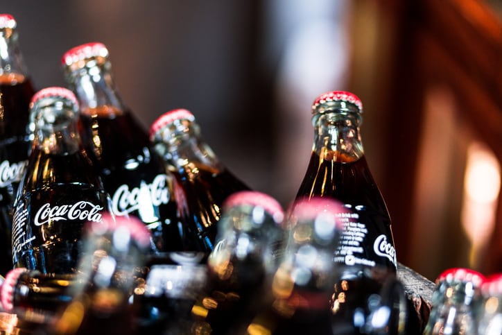 London, UK - January 17, 2015: glass bottles of Coca Cola for sale inside a wooden barrel at Borough Market, London, UK. Borough Market is a wholesale and retail food market in Southwark, Central London, England. It is one of the largest and oldest food markets in London, and sells a large variety of foods from all over the world. Colour image with lots of room for copy space.
