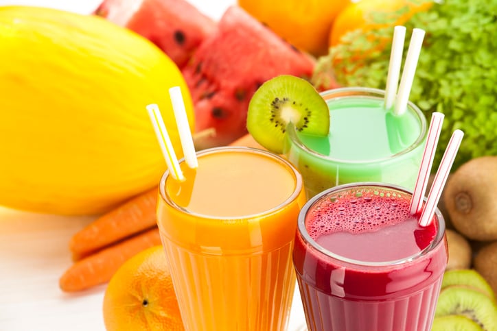 Close Up of Three Glasses of Fruit Juices on White Garden Table. High Angle View.