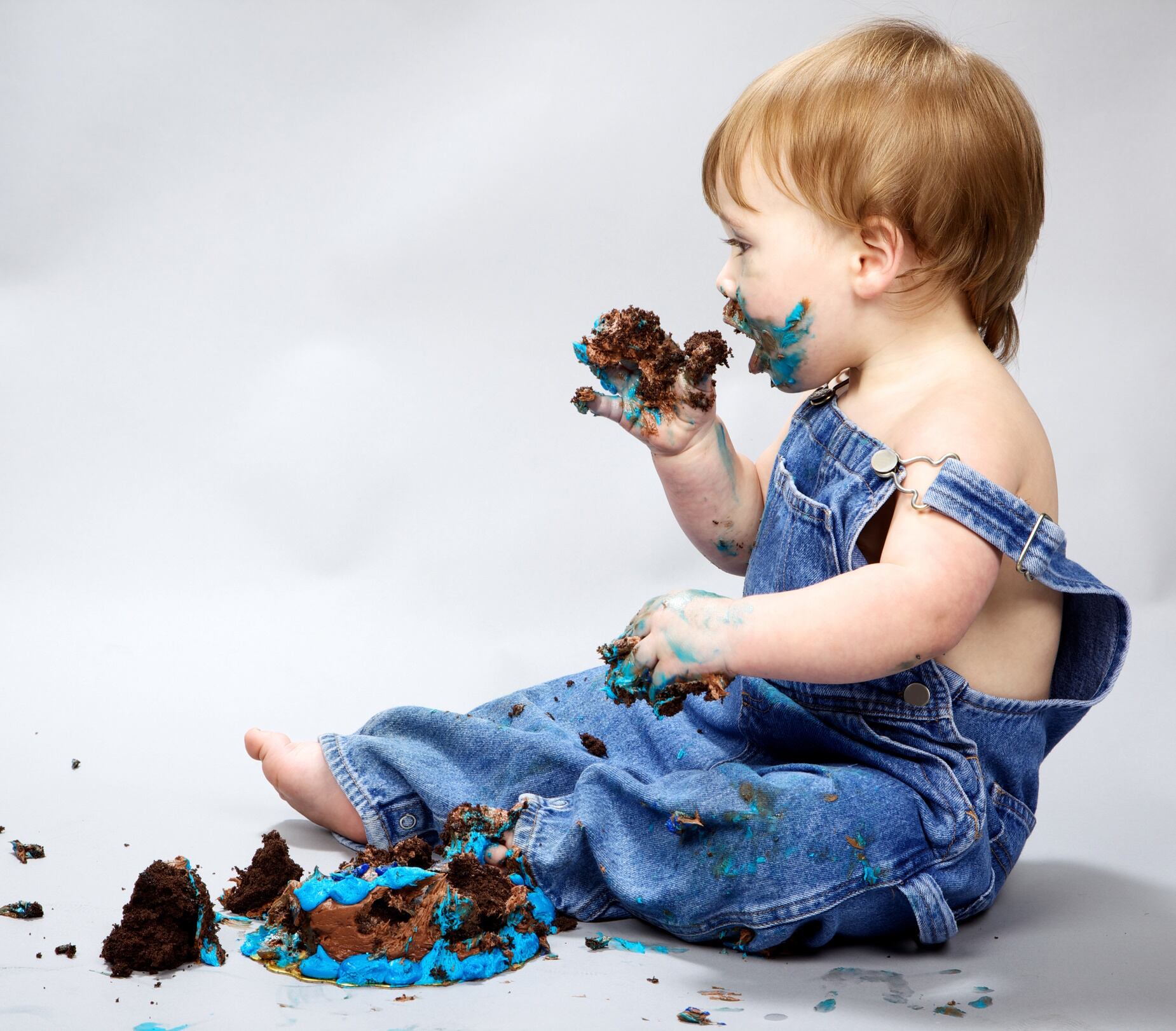 Messy toddler eating birthday cake