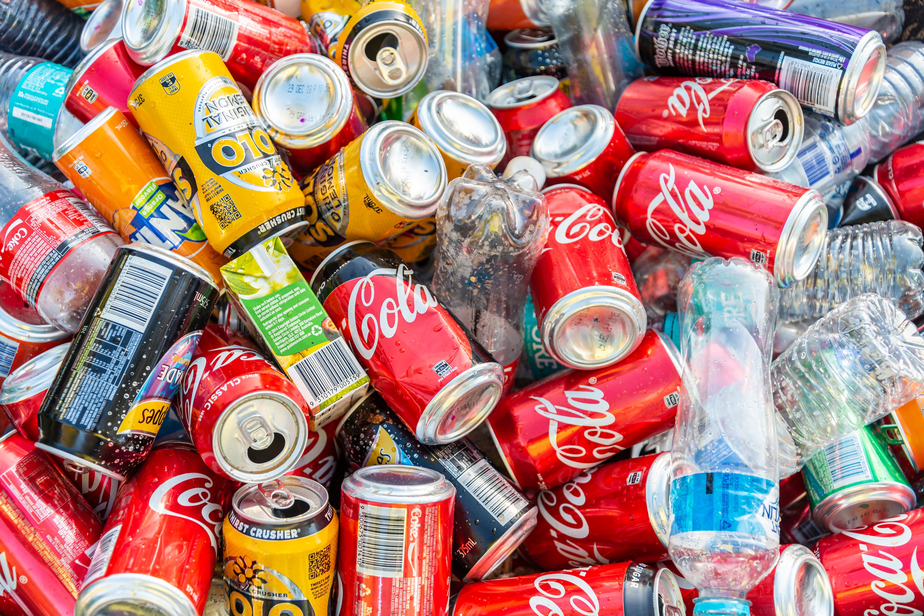 Pile of soft drink cans and plastic bottles collected after public event and ready for recycling