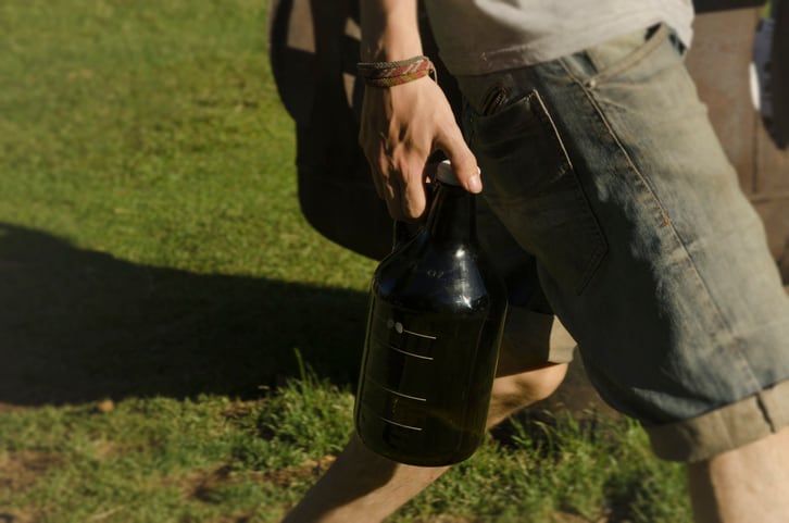 young man carrying craft beer growler to recharge