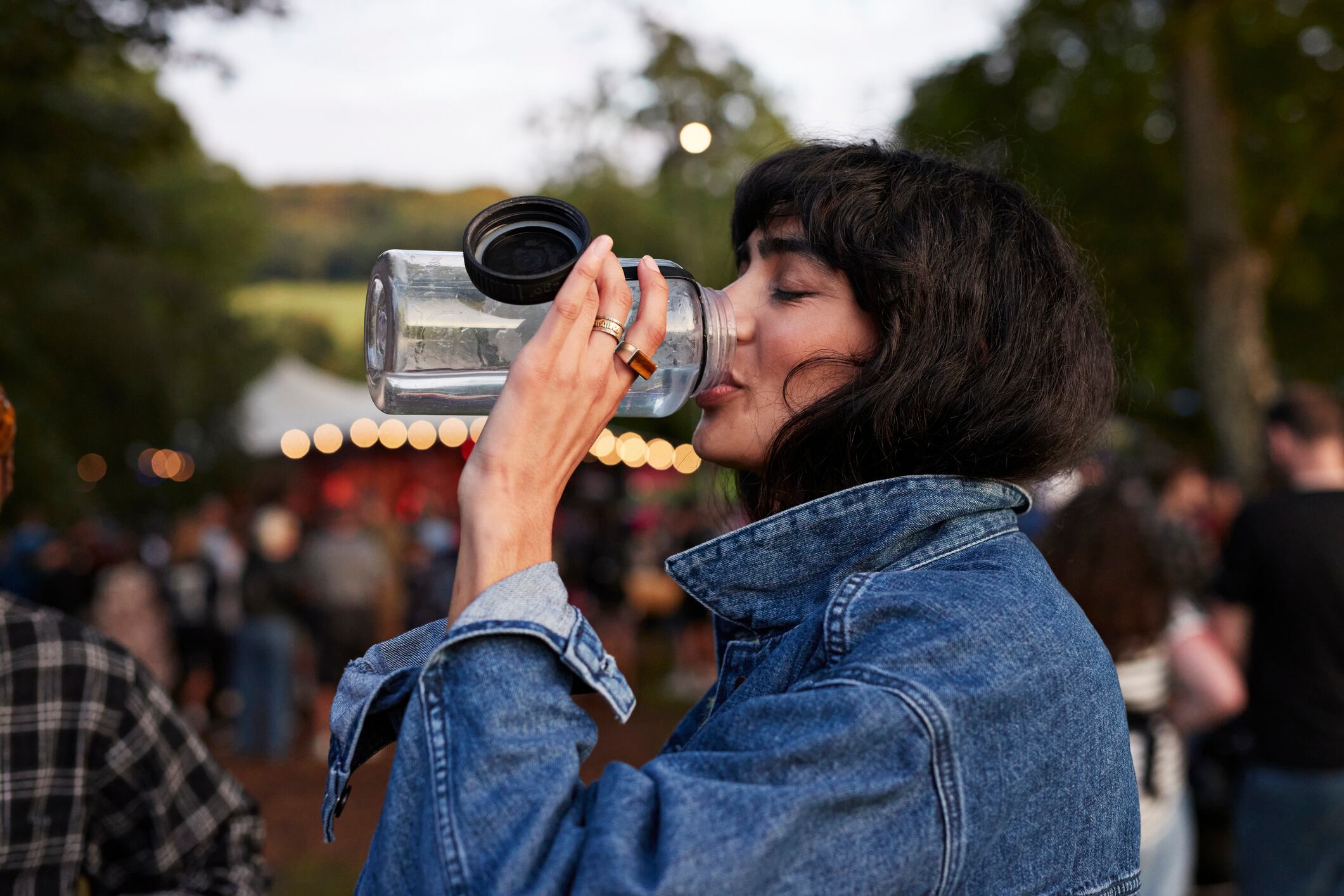 Woman drinking water at a festival.